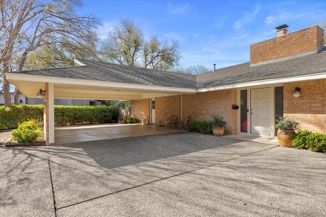 3106 Maywood Ave, Austin, TX 78703 - exterior space with brick siding, concrete driveway, a chimney, and roof with shingles