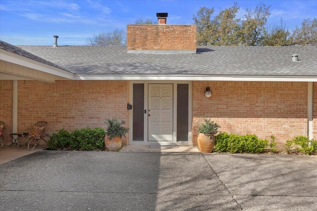 3106 Maywood Ave, Austin, TX 78703 - property entrance featuring a chimney, a shingled roof, and brick siding