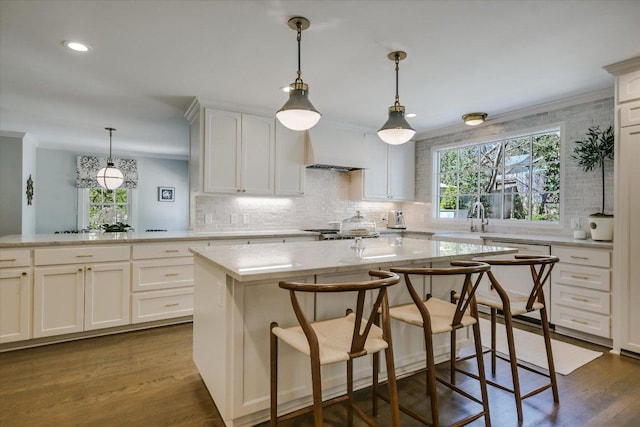 1710 Mccall Rd, Austin, TX 78703 - kitchen with decorative backsplash, a kitchen island, a breakfast bar, dark wood-style floors, and recessed lighting