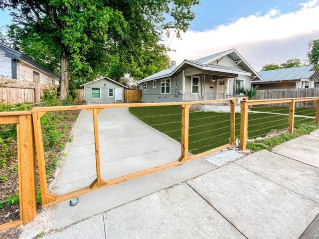 ranch-style home with an outdoor structure, a front lawn, and a fenced front yard