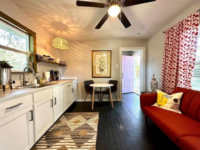 living room with dark wood-style floors, baseboards, and a ceiling fan