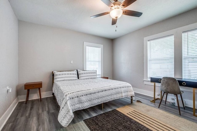 bedroom featuring dark wood-type flooring, baseboards, and a ceiling fan