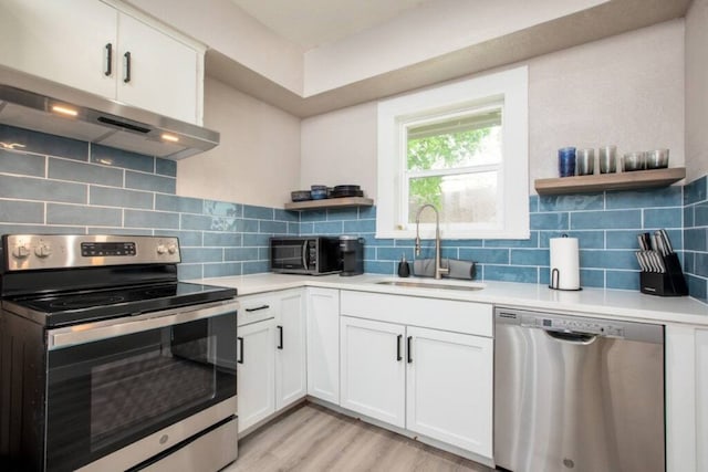 kitchen with under cabinet range hood, a sink, open shelves, and appliances with stainless steel finishes