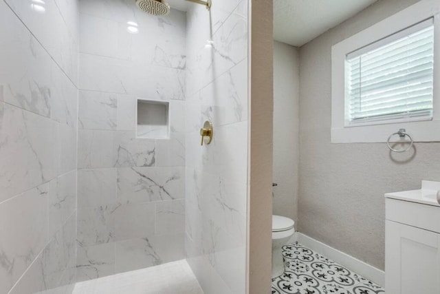 full bathroom featuring a marble finish shower, toilet, vanity, and baseboards