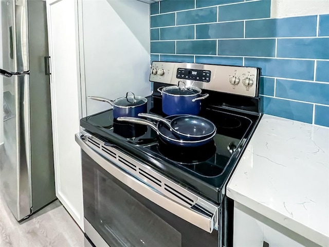 kitchen featuring appliances with stainless steel finishes and light stone counters