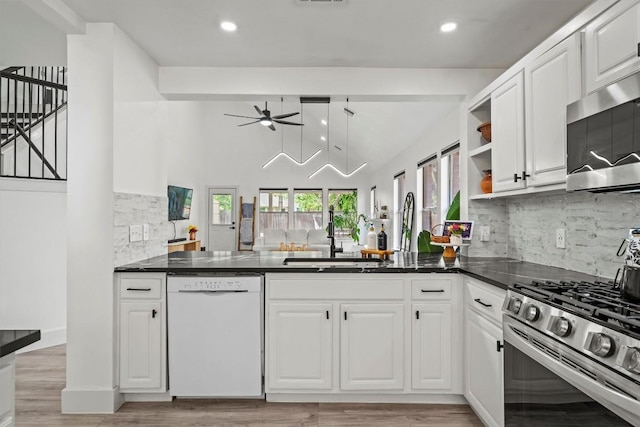 13436 Moscow Trl, Austin, TX 78729 - kitchen featuring appliances with stainless steel finishes, ceiling fan, a peninsula, backsplash, and white cabinets