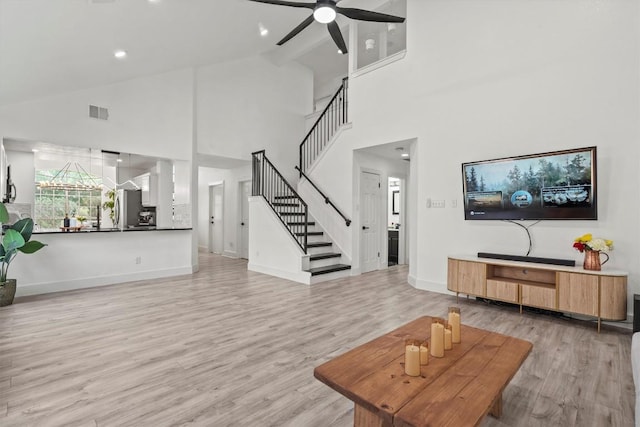 living area with stairway, ceiling fan, light wood-style flooring, and visible vents