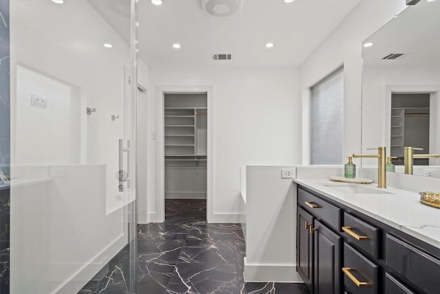 13436 Moscow Trl, Austin, TX 78729 - full bathroom featuring vanity, a spacious closet, marble finish floors, recessed lighting, and baseboards
