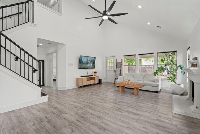 13436 Moscow Trl, Austin, TX 78729 - living room featuring high vaulted ceiling, stairway, a ceiling fan, baseboards, and wood finished floors