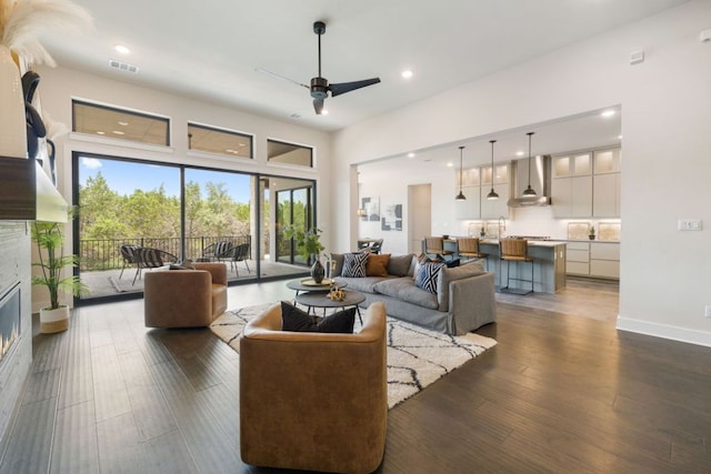 17809 Maritime Point Dr, Jonestown, TX 78645 - living area featuring visible vents, a glass covered fireplace, ceiling fan, dark wood-type flooring, and plenty of natural light