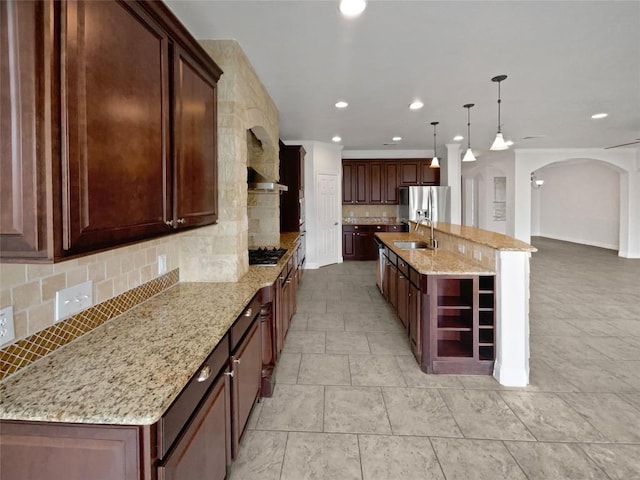 1985 Canyon Sage Path, Round Rock, TX 78665 - kitchen featuring appliances with stainless steel finishes, arched walkways, backsplash, recessed lighting, and light stone countertops