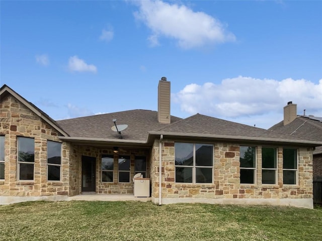 1985 Canyon Sage Path, Round Rock, TX 78665 - rear view of house with stone siding, a chimney, a patio, a lawn, and roof with shingles