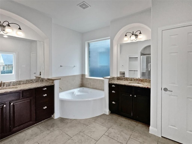 1985 Canyon Sage Path, Round Rock, TX 78665 - bathroom featuring a garden tub, two vanities, and a stall shower
