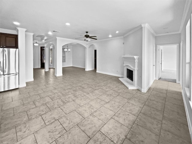 1985 Canyon Sage Path, Round Rock, TX 78665 - unfurnished living room featuring recessed lighting, a fireplace with raised hearth, a ceiling fan, crown molding, and arched walkways
