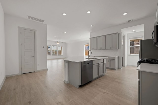 408 Tinto St, Leander, TX 78641 - kitchen featuring stainless steel appliances, gray cabinetry, a sink, light wood-style floors, and open floor plan