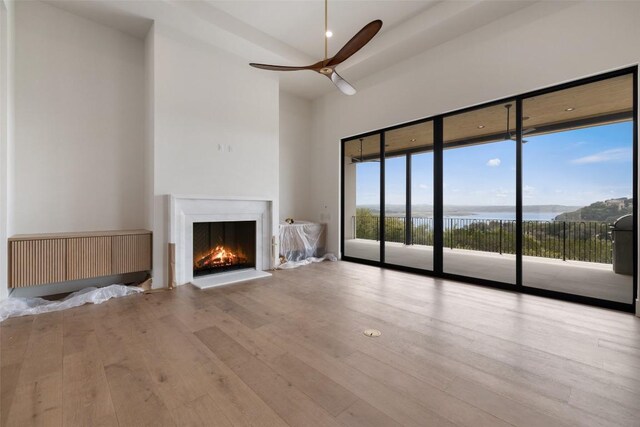 19538 Sandcastle Dr, Spicewood, TX 78669 - unfurnished living room with ceiling fan, a warm lit fireplace, and wood finished floors