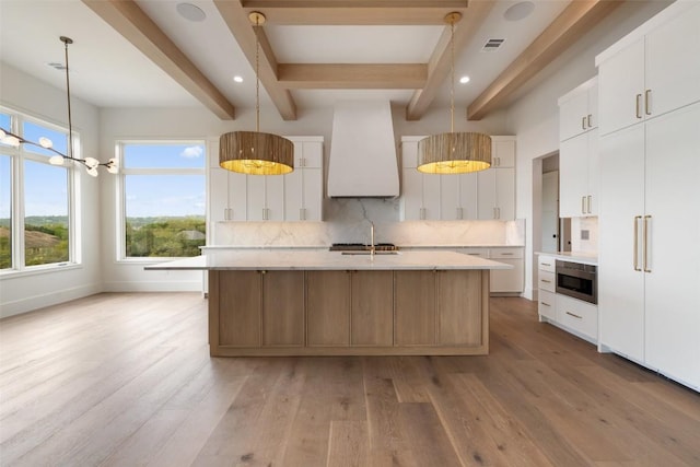 19538 Sandcastle Dr, Spicewood, TX 78669 - kitchen with premium range hood, backsplash, visible vents, and light wood-type flooring