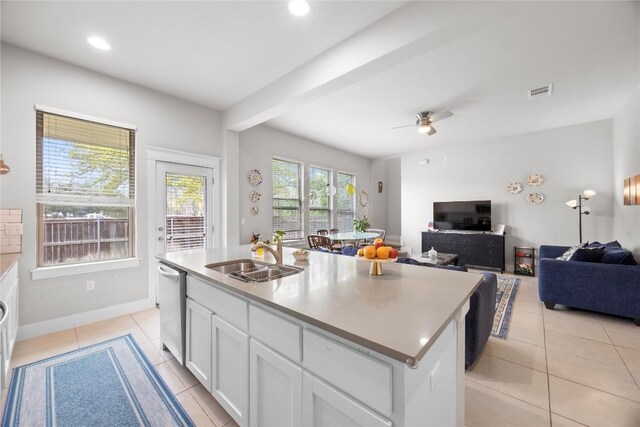 13001 Hymeadow Dr Unit 12, Austin, TX 78729 - kitchen featuring a sink, dishwasher, light tile patterned floors, white cabinetry, and an island with sink