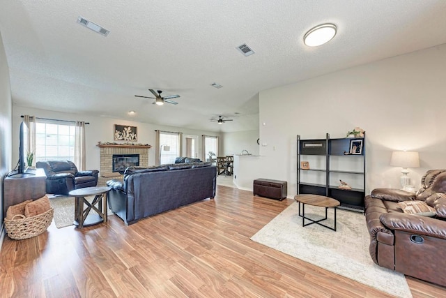 602 Totem Trl, Harker Heights, TX 76548 - living room with ceiling fan, light wood-style floors, a brick fireplace, and a textured ceiling