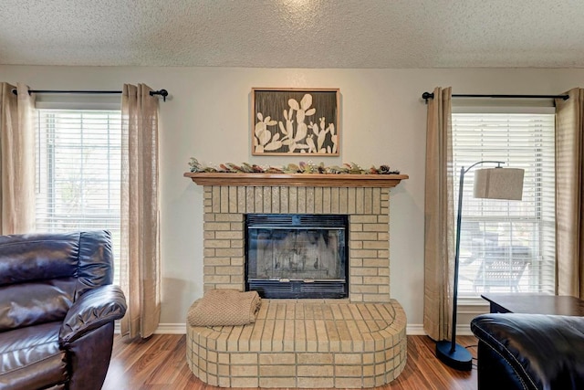 602 Totem Trl, Harker Heights, TX 76548 - living room with a textured ceiling, wood finished floors, and a brick fireplace