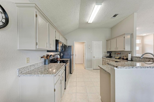 602 Totem Trl, Harker Heights, TX 76548 - kitchen with appliances with stainless steel finishes, lofted ceiling, a peninsula, light stone counters, and a textured ceiling