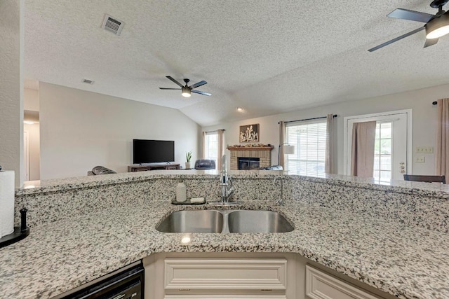 602 Totem Trl, Harker Heights, TX 76548 - kitchen with ceiling fan, open floor plan, a brick fireplace, light stone countertops, and a textured ceiling