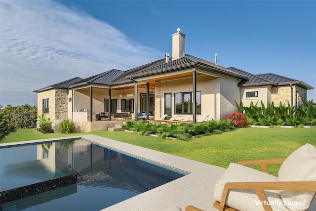 back of property featuring a standing seam roof, a patio, a chimney, and stucco siding