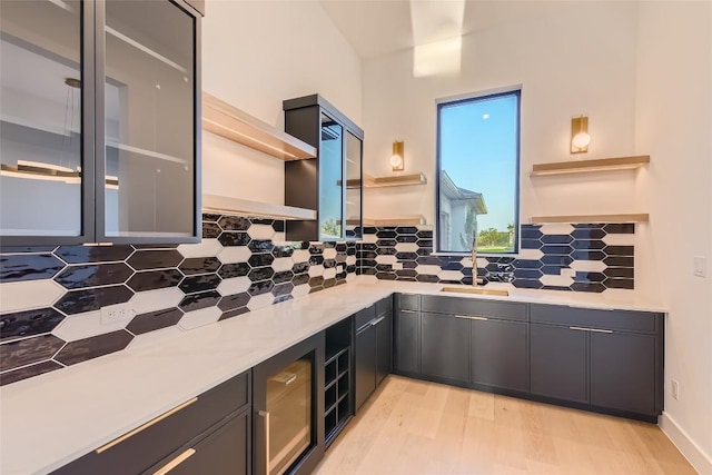 kitchen featuring open shelves, decorative backsplash, light countertops, and light wood finished floors