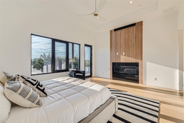 bedroom featuring recessed lighting, wood finished floors, ceiling fan, and a high ceiling