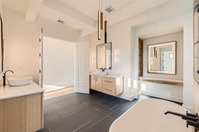 bathroom with a soaking tub, two vanities, and tile patterned floors