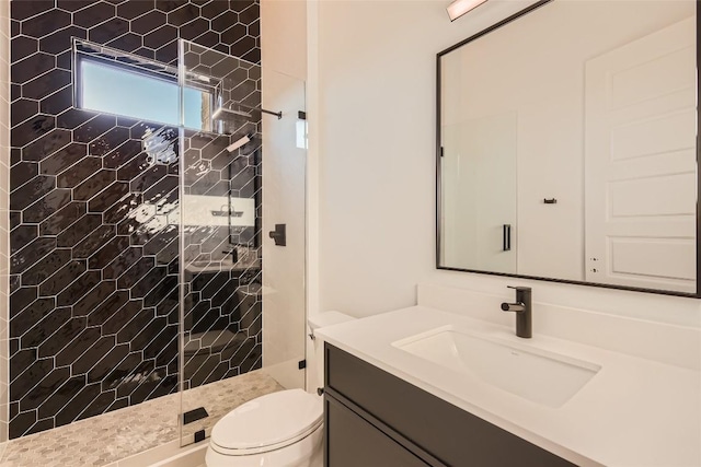 bathroom with a stall shower, toilet, and vanity