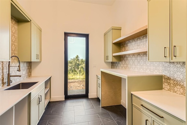 kitchen featuring open shelves, a sink, tasteful backsplash, and light countertops