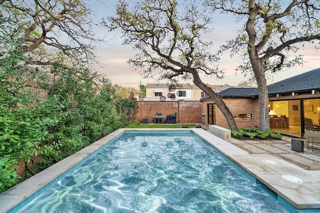 view of pool featuring a patio, grilling area, and fence