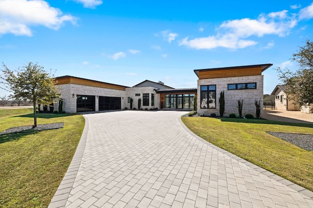 420 Waters Edge Cv, Dripping Springs, TX 78620 - contemporary home featuring stone siding, curved driveway, an attached garage, and a front yard