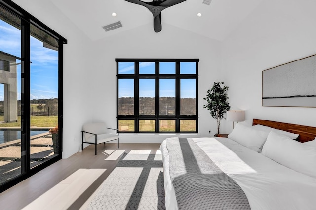 420 Waters Edge Cv, Dripping Springs, TX 78620 - bedroom featuring wood finished floors, high vaulted ceiling, visible vents, and multiple windows