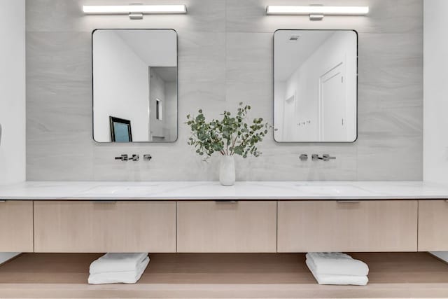 420 Waters Edge Cv, Dripping Springs, TX 78620 - bathroom with a sink, double vanity, tile walls, and decorative backsplash