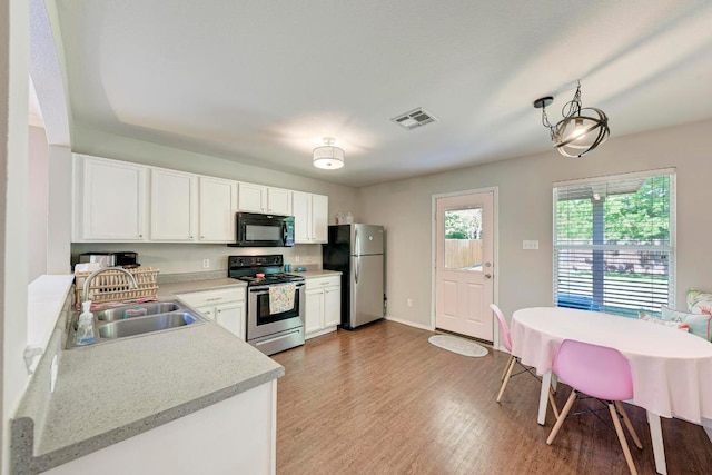 117 Easy St, Hutto, TX 78634 - kitchen featuring stainless steel appliances, a sink, light countertops, light wood-style flooring, and white cabinetry