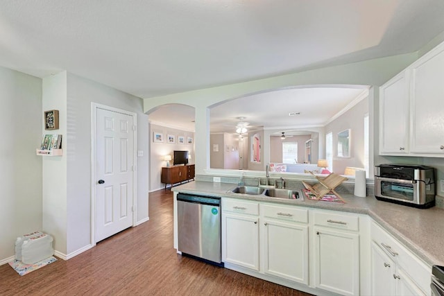 117 Easy St, Hutto, TX 78634 - kitchen featuring stainless steel dishwasher, a sink, arched walkways, wood finished floors, and crown molding