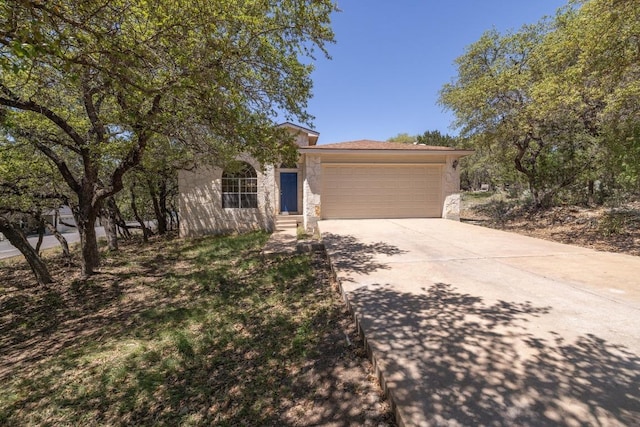 2300 Nevins Cv, Lago Vista, TX 78645 - view of front of house with driveway, stone siding, and a garage