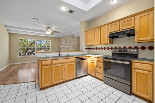2300 Nevins Cv, Lago Vista, TX 78645 - kitchen featuring stainless steel appliances, extractor fan, a peninsula, backsplash, and a ceiling fan
