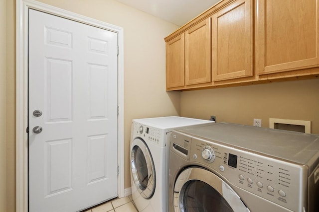 2300 Nevins Cv, Lago Vista, TX 78645 - washroom with cabinet space, washer and dryer, and light tile patterned floors