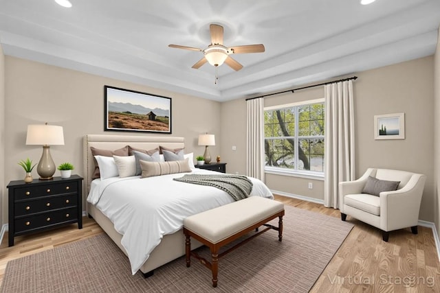 2300 Nevins Cv, Lago Vista, TX 78645 - bedroom featuring light wood-style floors, recessed lighting, ceiling fan, and a raised ceiling