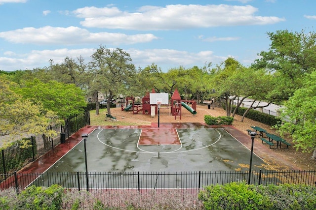 view of sport court featuring community basketball court, fence, and playground community
