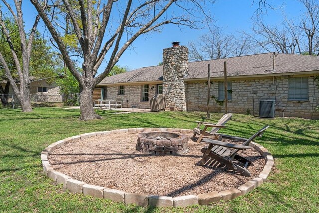 1604 Robb Ln, Round Rock, TX 78664 - back of property featuring an outdoor fire pit, a yard, stone siding, and a chimney