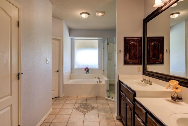 200 Matzig Cv, Buda, TX 78610 - full bath featuring double vanity, a bath, a shower stall, tile patterned floors, and baseboards