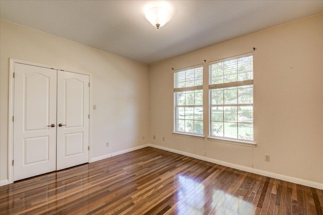 200 Matzig Cv, Buda, TX 78610 - unfurnished bedroom featuring hardwood / wood-style floors, baseboards, and a closet