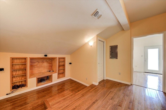 200 Matzig Cv, Buda, TX 78610 - unfurnished living room featuring lofted ceiling, built in shelves, wood finished floors, and baseboards