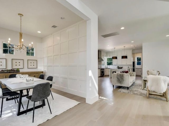 2000 Raleigh Ave, Austin, TX 78703 - dining area featuring a chandelier, light wood-style flooring, a decorative wall, and recessed lighting