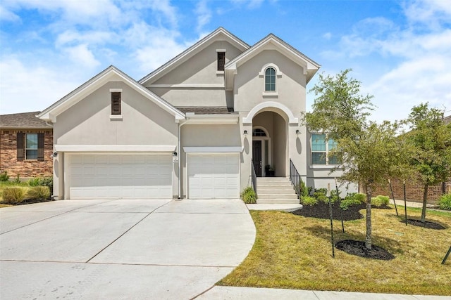 124 Adina Dr, Dripping Springs, TX 78620 - view of front facade featuring stucco siding, driveway, a front yard, and a garage