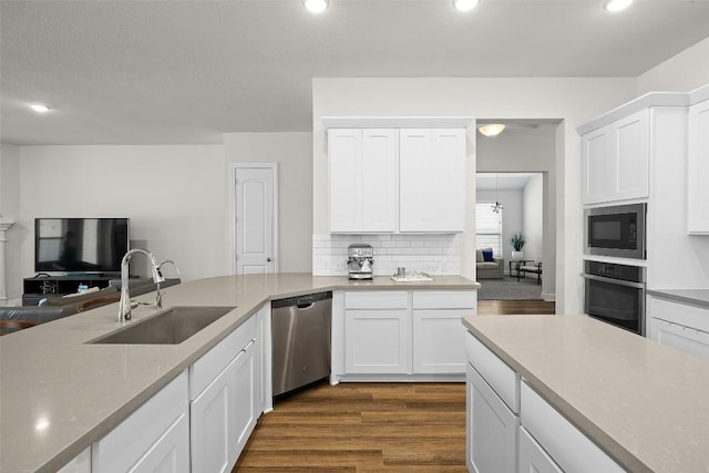 124 Adina Dr, Dripping Springs, TX 78620 - kitchen with appliances with stainless steel finishes, a sink, dark wood-style floors, white cabinetry, and recessed lighting